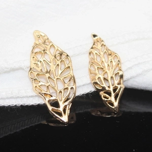 Macro shot of two golden hollow leaf charms for DIY bridal hair accessories