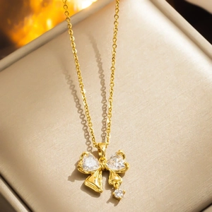 Golden butterfly necklace with sparkling crystals displayed on a beige jewelry box