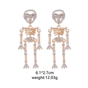 Detail view of punk style gold skeleton earrings with white rhinestones and size data