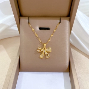 Luxurious gold stainless steel jewelry set featuring a sparkling zircon bow pendant