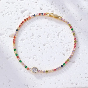 Gold-plated rainbow tennis bracelet with multi-color cubic zirconia on a stone surface