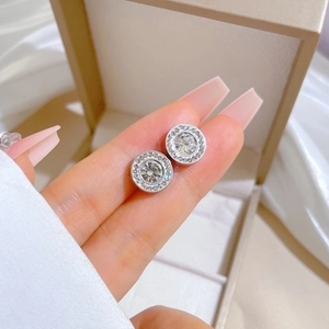 Titanium steel stud earrings with large round zircon and halo crystals held by hand