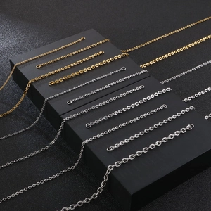 Minimalist gold and silver O-chain necklaces displayed on geometric blocks