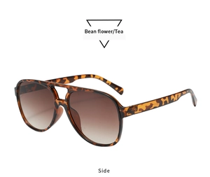 Detail view of retro leopard print aviator sunglasses with dual-bridge frame and tea lenses