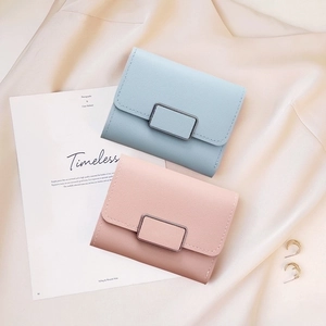 Detailed flat lay of minimalist light blue and pink floral embroidered women's wallets