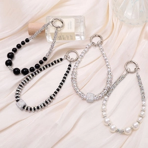 Detail van luxe kralen tashangers met strass-steentjes op een witte zijden achtergrond