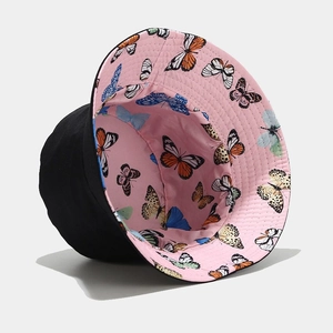 Detail view of reversible sun hat showing black exterior and pink butterfly pattern lining