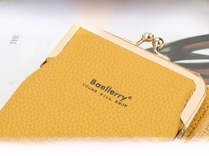 Macro shot of yellow PU leather bag with litchi texture and golden metal buckle details