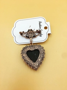 Macro shot of the vintage heart brooch back featuring a needle pin clasp mechanism