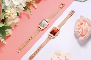 Close-up of elegant square dial watches with mesh straps and floral decoration