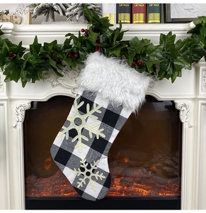 Close-up of black and white buffalo plaid Christmas stocking with white faux fur and snowflakes