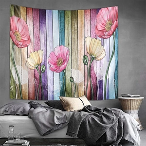 Detailed view of floral mountain tapestry with poppies hanging over a tidy bed
