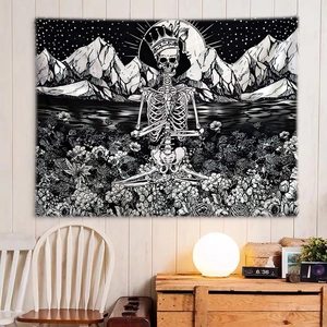 Detailed black and white gothic tapestry showing skull and floral art on a wooden wall
