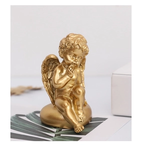 Gros plan de la figurine d'ange Cupidon doré avec ailes détaillées et geste de silence