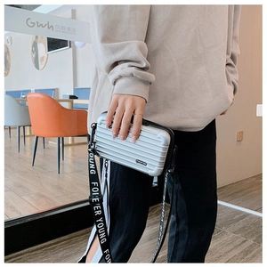 Silver mini suitcase crossbody bag with grooved hardshell and logo canvas strap