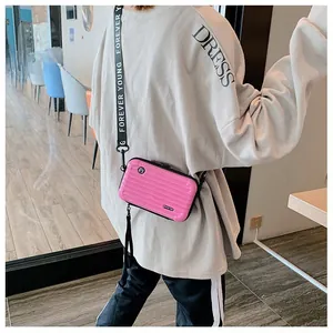 Detail of pink hardshell mini suitcase bag with Forever Young strap and ridged texture