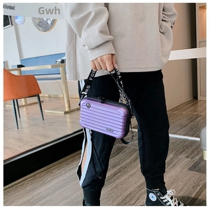 Detail of purple hard shell mini suitcase crossbody bag with Forever Young wide strap