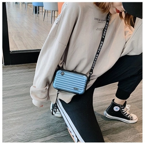 Blue mini suitcase-shaped crossbody bag with a trendy printed wide shoulder strap