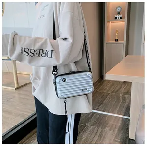 Silver mini suitcase crossbody bag with textured stripes and branded wide strap
