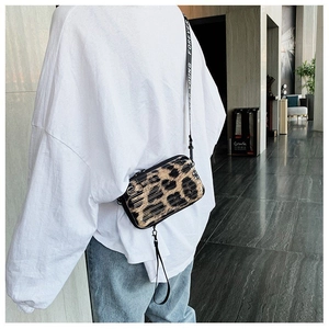 Close-up of leopard print hardshell mini crossbody bag with Forever Young strap