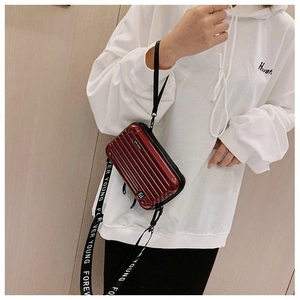 Detail of burgundy suitcase-style mini crossbody bag with Forever Young strap