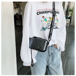 Detailed view of gray mini suitcase crossbody bag with Forever Young strap and ribbed shell