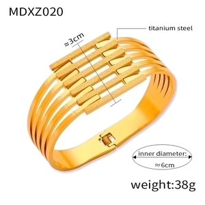 Detailed view of wide gold-plated titanium steel cuff with multi-layer hollow design