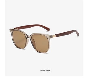 Detail of retro tea-tinted sunglasses with wooden grain temples and gold metal hinges