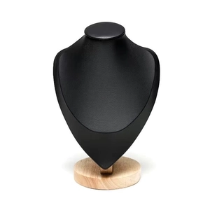 Detail of black leather necklace bust display with a solid round wooden base