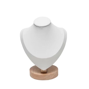 Detail of white leather bust jewelry display with round solid wood base for necklaces