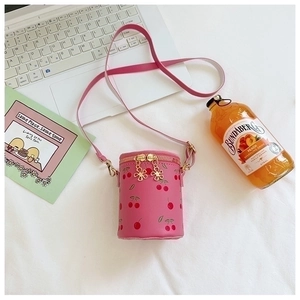 Detail view of pink cherry print cylinder bag with floral metal double zippers