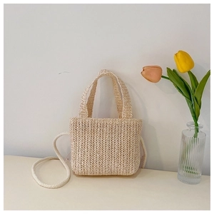 Straw woven shoulder bag for kids with tulip flower decor in a minimalist natural setting