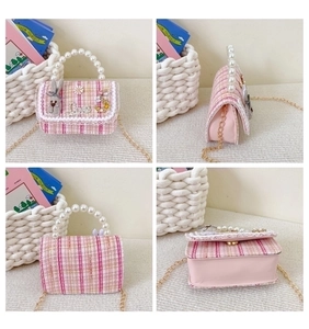 Detail view of pink tweed girls handbag with pearl handle and floral bunny charms