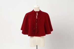 Close-up of red cable knit Christmas tree skirt with bow ties and rich texture details