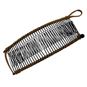 Detailed view of banana hair clip with brown braided rope and black metal comb teeth
