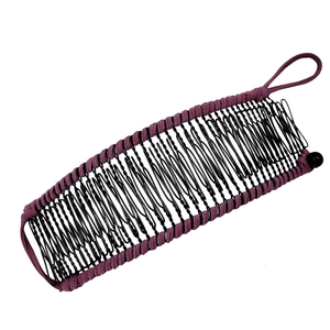 Close-up of purple fabric edge and black wavy wire metal banana hair clip detail