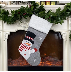 Detail of grey felt Christmas stocking with snowman applique and white plush cuff