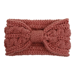 Détails de la maille du bandeau rose à torsades avec un nœud central élégant