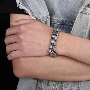 Detail of vintage silver stainless steel chain bracelet with Sanskrit engravings on wrist