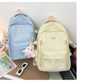 Gros plan du sac à dos texturé avec breloque lapin mignonne et poche latérale pratique