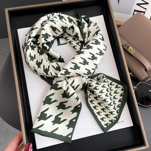 Elegant dark green and cream houndstooth skinny silk scarf on black display tray
