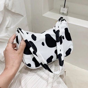 Detail shot of black and white cow print shoulder bag in high quality canvas material