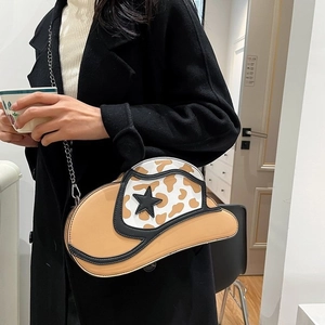 Unique cow print denim hat shaped chain shoulder bag with a black star accent