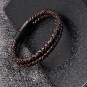 Macro shot of men's double-wrap braided leather bracelet with matte black magnetic clasp