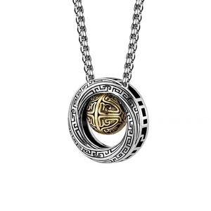 Detailed close-up of a silver Mobius ring pendant with a golden globe and vintage totems