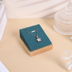 Detail of star pendant necklace with white zircon on a luxury green velvet display stand