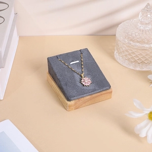 Detail of pink floral pendant necklace on premium grey velvet jewelry display stand
