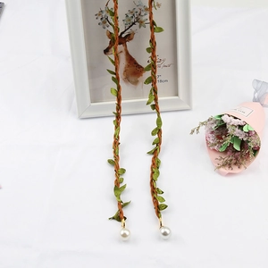 Detail of hand-woven cotton linen waist rope with green leaf tassels and white pearls