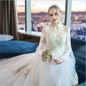 Off-shoulder lace wedding gown with long sheer sleeves and intricate embroidery
