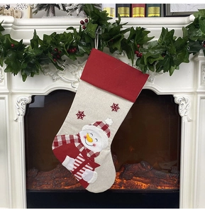 Detail of red and beige Christmas stocking with a snowman applique on a mantelpiece